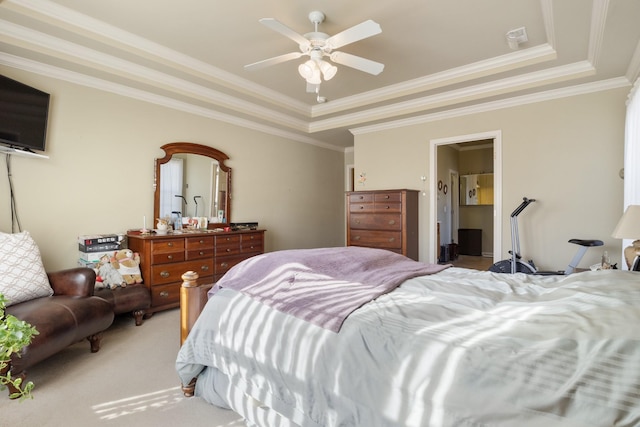 carpeted bedroom with a tray ceiling, ornamental molding, and ceiling fan