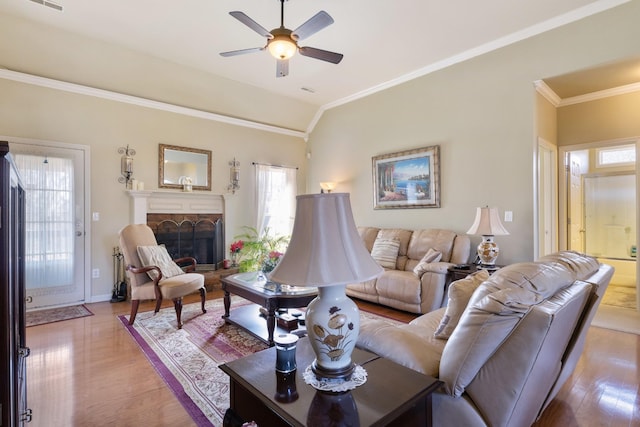 living room with crown molding, vaulted ceiling, ceiling fan, and light hardwood / wood-style flooring