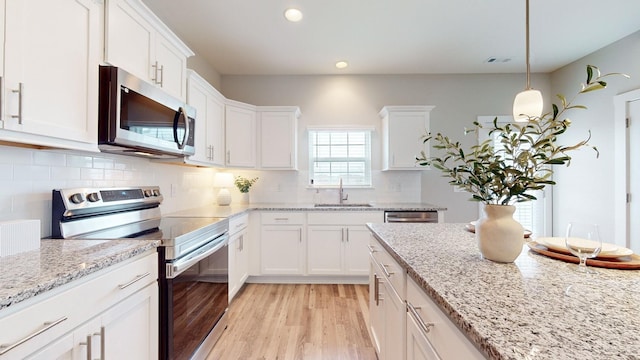 kitchen featuring white cabinetry, appliances with stainless steel finishes, sink, and pendant lighting