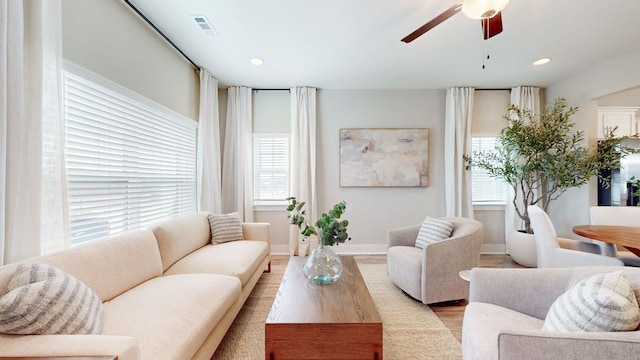 living room with a healthy amount of sunlight, ceiling fan, and light hardwood / wood-style flooring