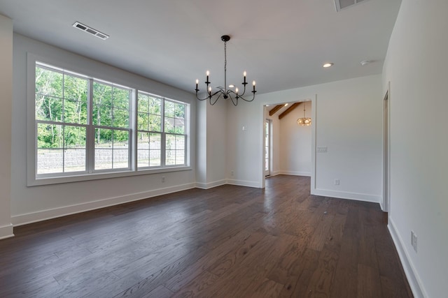 empty room featuring a notable chandelier and dark wood-type flooring