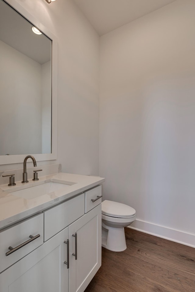 bathroom with vanity, wood-type flooring, and toilet