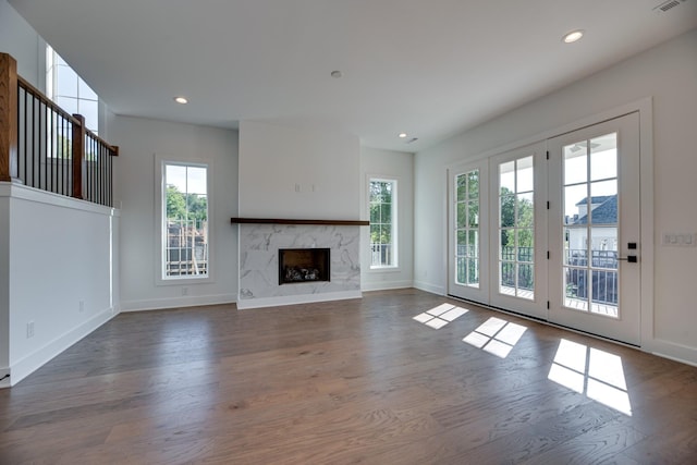 unfurnished living room with a high end fireplace and dark wood-type flooring