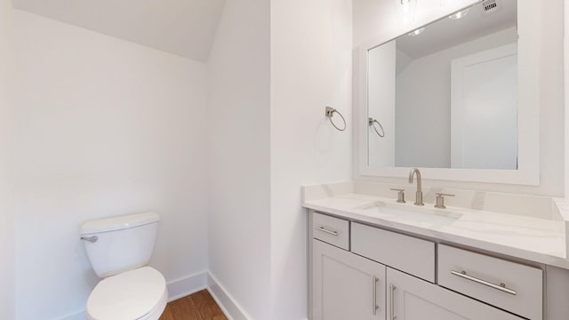 bathroom featuring hardwood / wood-style flooring, vanity, and toilet