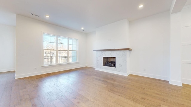 unfurnished living room featuring a fireplace and light hardwood / wood-style flooring