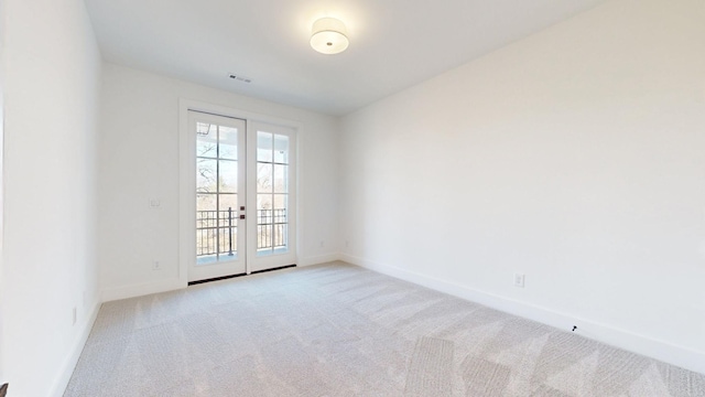 empty room featuring light colored carpet and french doors