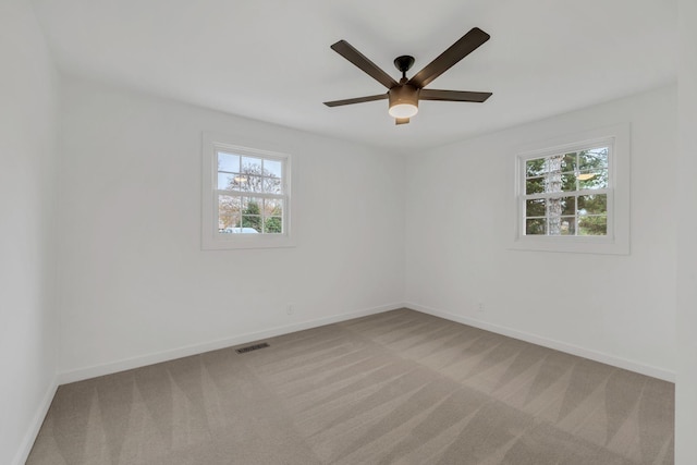 carpeted spare room with ceiling fan