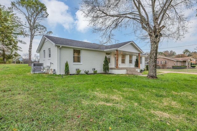 ranch-style home with cooling unit and a front lawn