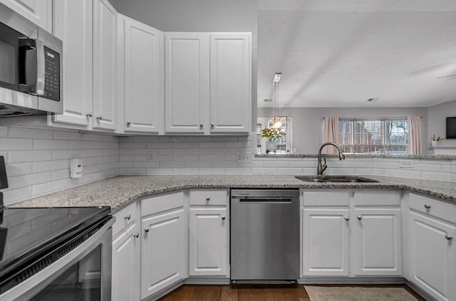 kitchen featuring a healthy amount of sunlight, appliances with stainless steel finishes, white cabinets, and a sink