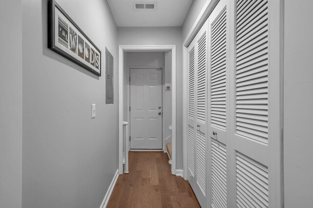 hall featuring baseboards, electric panel, visible vents, and dark wood finished floors