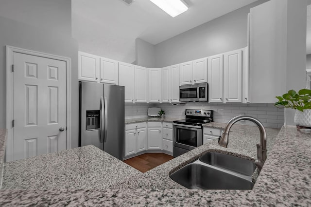 kitchen with stainless steel appliances, white cabinets, and a sink