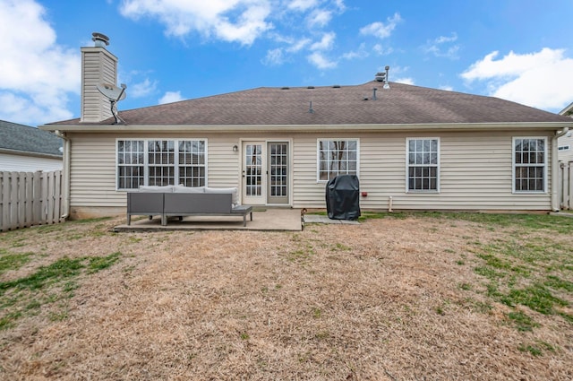 rear view of property featuring a patio, a fenced backyard, a chimney, roof with shingles, and an outdoor living space