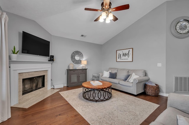 living area with lofted ceiling, a fireplace, visible vents, and dark wood finished floors