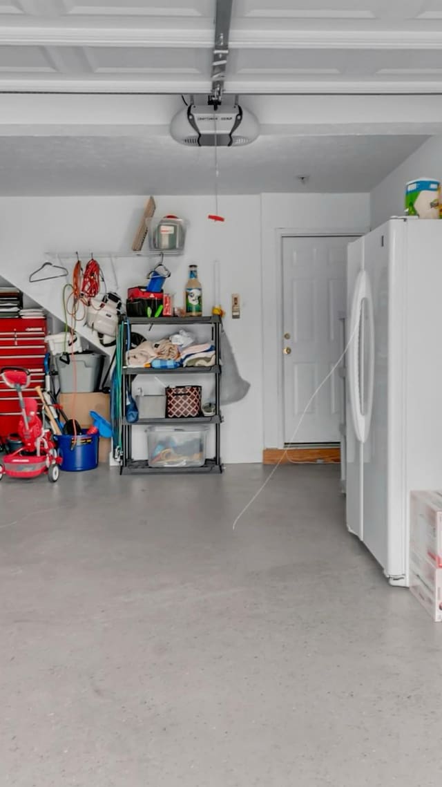 garage featuring a garage door opener and freestanding refrigerator