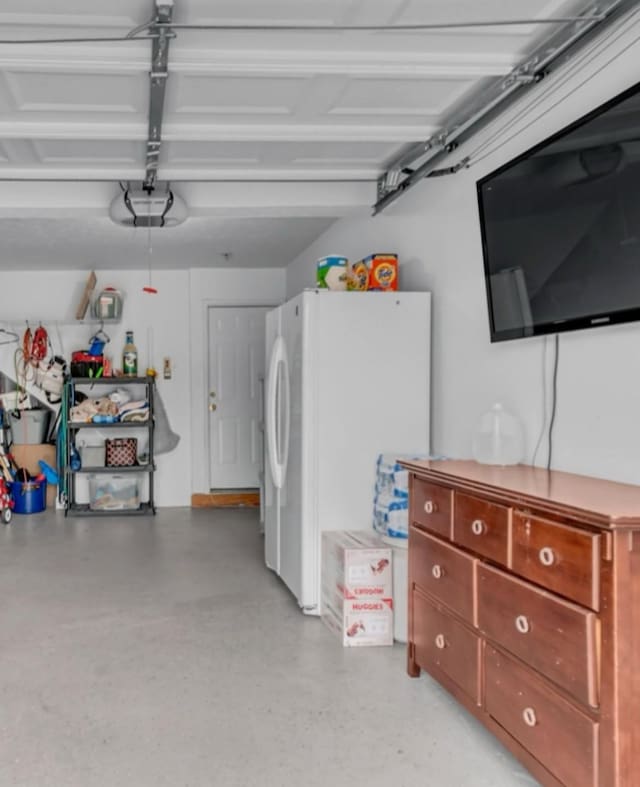 garage featuring a garage door opener and freestanding refrigerator