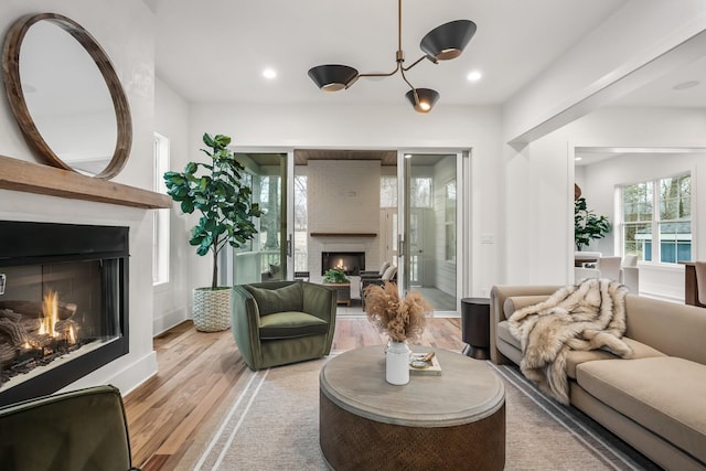 living room with a large fireplace and light hardwood / wood-style flooring