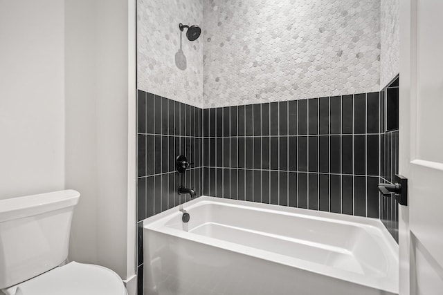 bathroom featuring tiled shower / bath combo and toilet