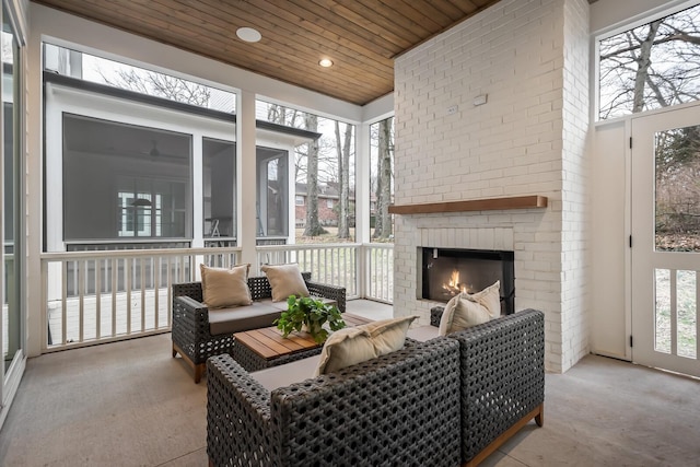 sunroom with a fireplace and wood ceiling