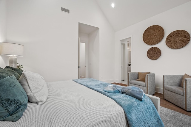 bedroom featuring high vaulted ceiling and hardwood / wood-style floors