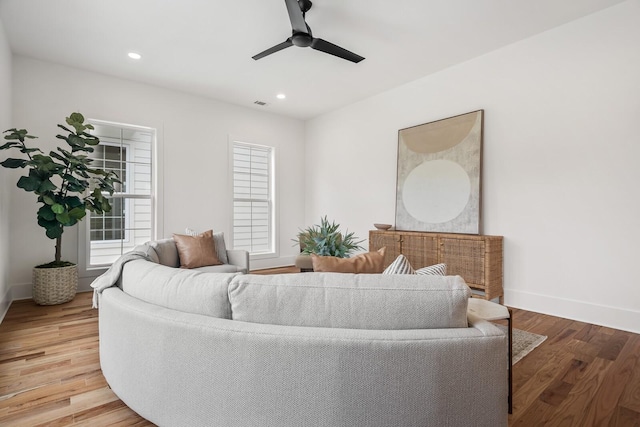 living room featuring hardwood / wood-style floors and ceiling fan