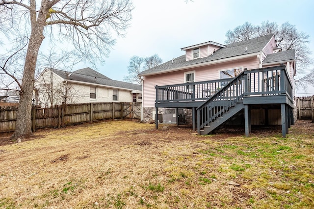 rear view of house featuring a deck and a lawn