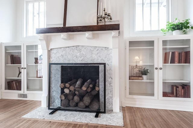 details featuring a tiled fireplace, hardwood / wood-style floors, and french doors