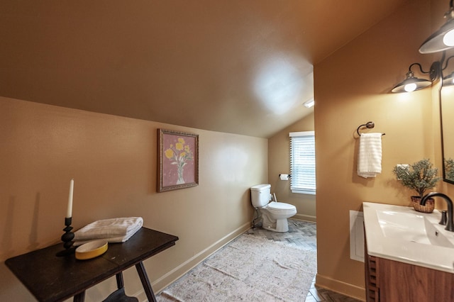 bathroom featuring lofted ceiling, vanity, and toilet