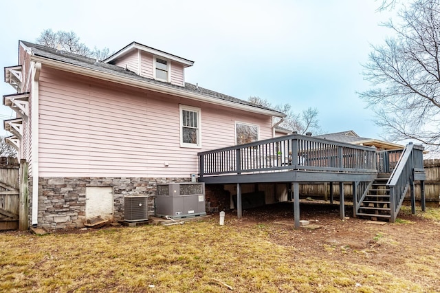 back of property featuring a wooden deck, a lawn, and central air condition unit