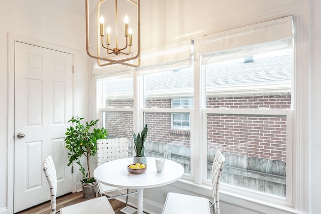 dining space featuring breakfast area, hardwood / wood-style floors, and an inviting chandelier