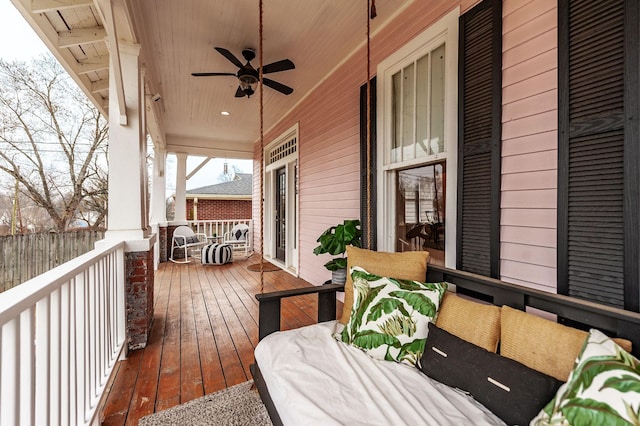 wooden terrace featuring covered porch and ceiling fan