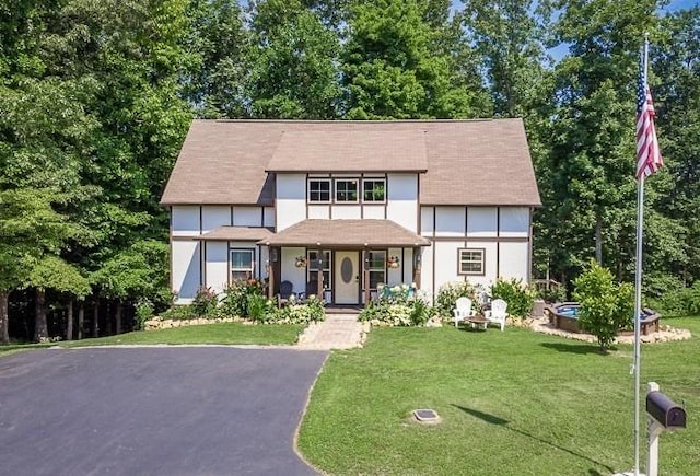 tudor house with covered porch and a front lawn