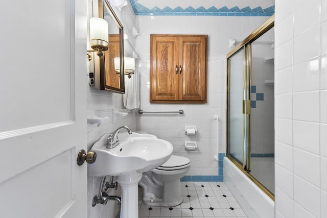 bathroom featuring bath / shower combo with glass door, tile walls, tile patterned floors, and toilet