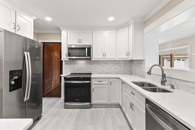 kitchen with stainless steel appliances, sink, white cabinets, and backsplash