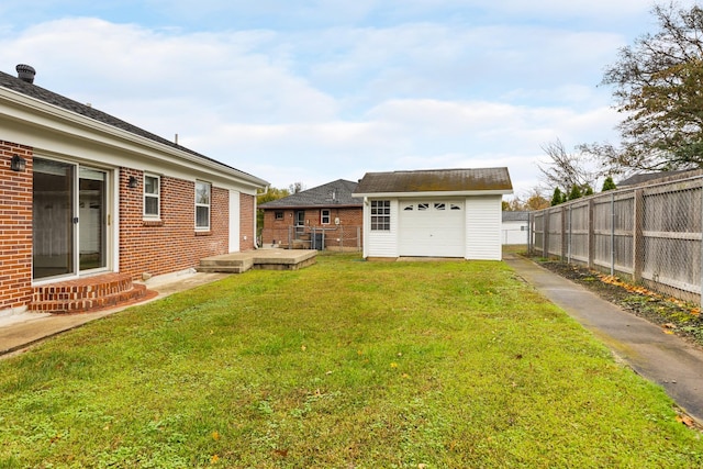 view of yard featuring a garage, a wooden deck, and an outdoor structure