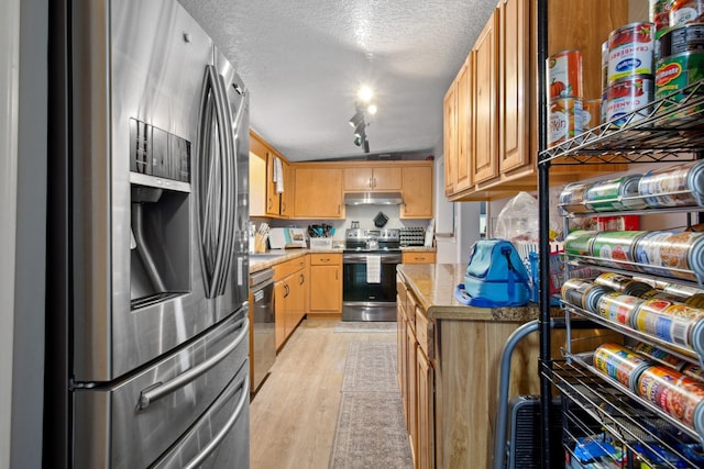 kitchen with rail lighting, appliances with stainless steel finishes, light brown cabinets, a textured ceiling, and light wood-type flooring