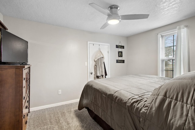 bedroom featuring ceiling fan, carpet, and a textured ceiling