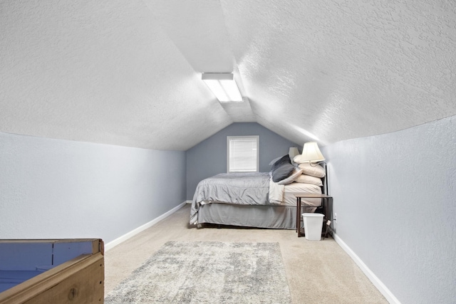 bedroom with lofted ceiling, carpet floors, and a textured ceiling