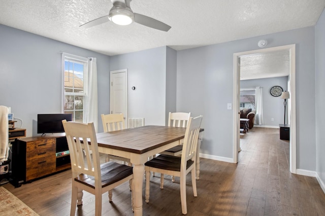 dining space featuring wood-type flooring, ceiling fan, and a textured ceiling