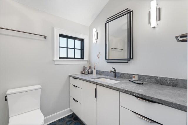 bathroom with vanity, lofted ceiling, and toilet