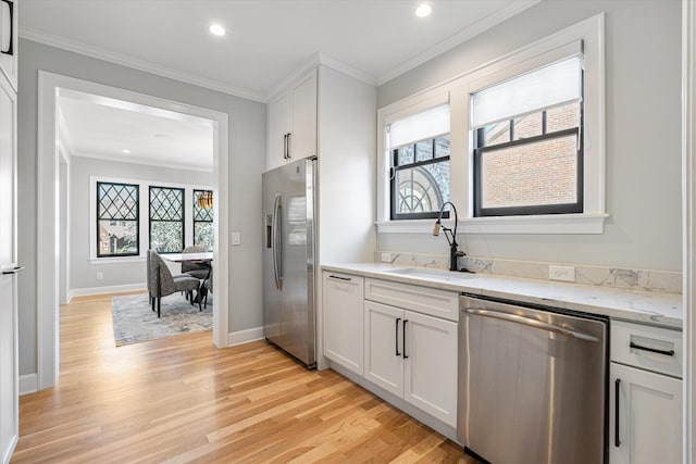 kitchen featuring crown molding, appliances with stainless steel finishes, sink, and white cabinets