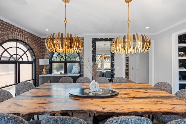 dining space with ornamental molding, brick wall, and an inviting chandelier