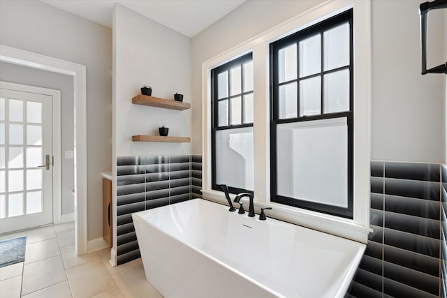 bathroom with tile patterned flooring and a tub