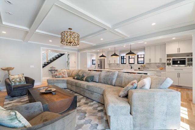 living room featuring sink, coffered ceiling, light hardwood / wood-style floors, and beam ceiling