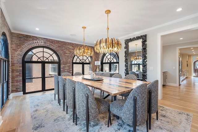 dining space with light hardwood / wood-style flooring, ornamental molding, a healthy amount of sunlight, and brick wall