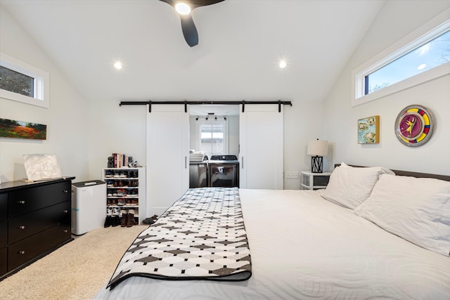 bedroom with multiple windows, vaulted ceiling, and a barn door