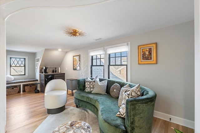 living room featuring wine cooler, wood-type flooring, and a healthy amount of sunlight