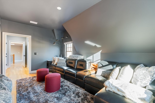 home theater featuring lofted ceiling and light wood-type flooring