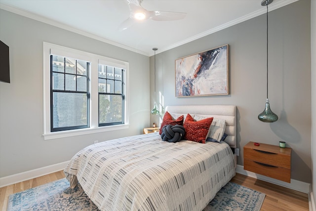 bedroom featuring hardwood / wood-style flooring, ceiling fan, and crown molding