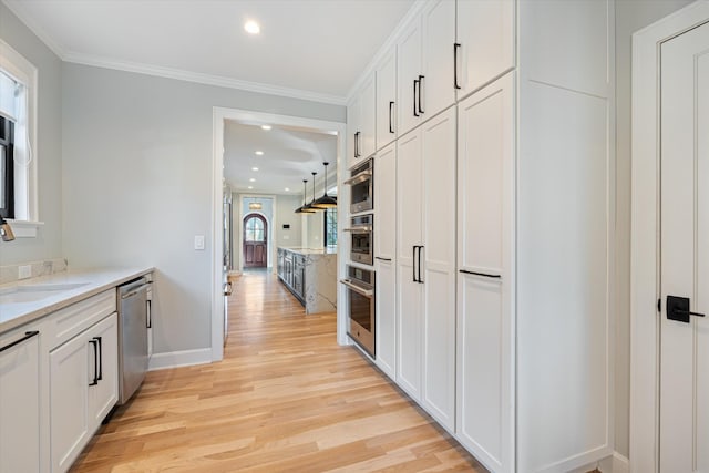 kitchen featuring stainless steel appliances, sink, white cabinets, and light wood-type flooring