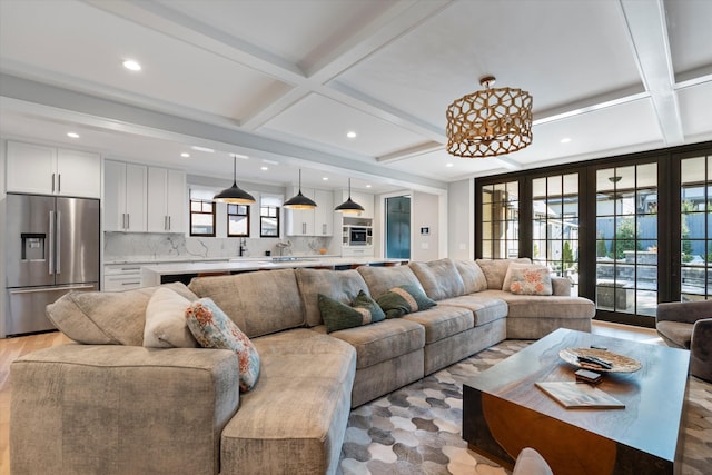 living room featuring coffered ceiling and beam ceiling